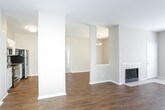 This single-floor residence offers a thoughtfully designed layout that balances open communal spaces with comfortable private areas. The main living area showcases warm hardwood-style flooring throughout and centers around a classic tiled fireplace, creating an inviting focal point. Large windows allow generous natural light to fill the room, while a chandelier adds an elegant touch to the adjacent dining area. The kitchen is equipped with stainless steel appliances, including a smooth-top electric range, over-the-range microwave, refrigerator, and dishwasher. White cabinetry pairs with granite-style countertops and a mosaic tile backsplash, lending a modern, clean aesthetic. The bedrooms feature plush carpeting and ceiling fans, with natural light provided by sizable windows with blinds. At least one bedroom includes a walk-in closet, offering ample storage. Two full bathrooms serve the residence, each finished with wood-style flooring, white vanity cabinetry, granite-style countertops, and a tub-shower combination. Neutral warm beige tones throughout the home create a cohesive, move-in-ready atmosphere suited to a variety of interior styles.