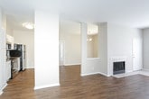 This single-floor residence offers a thoughtfully designed layout that balances open communal spaces with comfortable private areas. The main living area showcases warm hardwood-style flooring throughout and centers around a classic tiled fireplace, creating an inviting focal point. Large windows allow generous natural light to fill the room, while a chandelier adds an elegant touch to the adjacent dining area. The kitchen is equipped with stainless steel appliances, including a smooth-top electric range, over-the-range microwave, refrigerator, and dishwasher. White cabinetry pairs with granite-style countertops and a mosaic tile backsplash, lending a modern, clean aesthetic. The bedrooms feature plush carpeting and ceiling fans, with natural light provided by sizable windows with blinds. At least one bedroom includes a walk-in closet, offering ample storage. Two full bathrooms serve the residence, each finished with wood-style flooring, white vanity cabinetry, granite-style countertops, and a tub-shower combination. Neutral warm beige tones throughout the home create a cohesive, move-in-ready atmosphere suited to a variety of interior styles.
