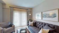 Located at 5927 Avery Wood Ave in Dublin, Ohio, this single-floor residence offers a well-organized, open-concept layout designed for comfortable everyday living. The living room serves as the heart of the home, featuring plush carpeting, neutral warm-toned walls, and a large sliding glass door dressed with vertical blinds and layered curtains that flood the room with natural light. The galley-style kitchen is outfitted with dark espresso cabinetry, granite-look countertops, black appliances including a refrigerator, electric range, dishwasher, and built-in microwave, complemented by hardwood-style flooring and a stainless steel sink. Adjacent to the kitchen, a dedicated dining area with pendant lighting provides a convenient space for meals. The primary bedroom is generously sized with carpet flooring, large windows with blinds and curtain panels, and ample room for substantial furniture. A second bedroom offers similar comfort with carpet flooring and bright window access. The full bathroom features a dark vanity with a granite-look countertop, a tub-shower combination, tile flooring, and well-lit mirrors. Throughout the residence, a cohesive neutral palette and consistent finishes create a calm, polished ambiance.