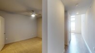 This two-story residence offers two bedrooms and two bathrooms thoughtfully arranged across its floors. The interior features a clean, neutral aesthetic with smooth walls finished in soft, warm tones throughout. Carpeted bedroom areas provide a comfortable underfoot feel, while hard surface flooring is present in the hallway and transitional spaces, creating a practical distinction between living zones. A ceiling fan is installed in one of the bedrooms, contributing both comfort and airflow to the space. The hallway connects the rooms efficiently, with a closeted storage area featuring double doors visible along the corridor. Natural light filters into the space through a window at the end of the hall, brightening the passage between rooms. The overall design is straightforward and well-maintained, with consistent baseboards and trim detailing throughout. The two-floor layout offers a sense of separation between living and sleeping areas, making the home adaptable for a variety of lifestyles. The neutral finishes and practical flooring choices create a versatile backdrop suitable for a range of furnishing styles.