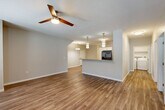 Located in Elkhorn, Nebraska, this well-appointed single-floor home offers three bedrooms, two bathrooms, and a thoughtfully designed open-concept layout. The combined kitchen and living area serves as the heart of the home, featuring warm hardwood-style flooring, a ceiling fan, and pendant lighting that creates an inviting atmosphere. The kitchen is equipped with stainless steel appliances, including a refrigerator with ice maker, electric range, and microwave, complemented by crisp white cabinetry, a tile backsplash, stone countertops, and a convenient breakfast bar peninsula. The spacious living and dining areas flow seamlessly, enhanced by clean neutral tones and abundant lighting. The bedrooms are carpeted for comfort, each featuring a ceiling fan and closet space. The primary bedroom offers a generous footprint with ample room for furnishings. The bathrooms are finished with tile flooring, and one includes a glass-enclosed walk-in shower with built-in shelving and accessibility grab bars. A dedicated laundry room houses a full-size washer and dryer with overhead shelving. The attached garage provides secure parking and additional storage. This home combines practical functionality with modern finishes throughout.