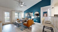 This well-appointed single-story home in San Marcos, Texas offers four bedrooms and four bathrooms across a thoughtfully designed open floor plan. A welcoming hallway lined with wood-look flooring leads seamlessly into the combined kitchen and living area, setting a bright and airy tone throughout. The living room is a standout space, featuring vaulted ceilings, a ceiling fan, and a bold teal accent wall that anchors the room with personality. Large windows invite generous natural light and frame outdoor views, complementing the open, comfortable atmosphere. The kitchen is outfitted with white shaker cabinetry, granite-style countertops, a herringbone tile backsplash, black appliances, and ample storage — all centered around a practical and stylish layout. A dedicated dining area sits adjacent, ideal for everyday meals or entertaining. Each bedroom features plush carpeting, large windows with abundant natural light, and unique accent wall colors that lend each room its own character. The four bathrooms are clean and modern, with wood-look tile flooring and soaking tubs. An in-unit laundry room houses a full-size washer and dryer. The screened-in patio, finished with teal shiplap walls and checkered flooring, offers a charming outdoor retreat with views of the surrounding greenery.