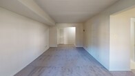 Located at 7422 Eastmoreland Rd in Annandale, Virginia, this single-floor residence offers a practical and comfortable layout throughout. The living areas are finished with wall-to-wall carpeting in neutral tones, creating a warm and cohesive feel across the space. A well-lit main room features a ceiling fan with an integrated light fixture and a sliding glass door fitted with vertical blinds, providing direct access to the outdoors and allowing generous natural light to fill the space. Additional carpeted rooms feature large windows with horizontal blinds, offering views of the surrounding neighborhood and maintaining a bright, airy atmosphere. One room includes a distinctive French door with multi-pane glass panels and exposed ceiling beams, adding architectural character. The kitchen is equipped with warm oak cabinetry, ample counter space, a gas range, and a full-size refrigerator, making it a functional space for everyday cooking. The bathroom includes tile flooring in a dark slate pattern, a wood-toned vanity with an integrated sink, and a mirrored medicine cabinet. The floor plan, as seen in the dollhouse view, reveals a thoughtfully arranged layout with clearly defined rooms, a staircase feature, and well-connected living spaces throughout the single level.