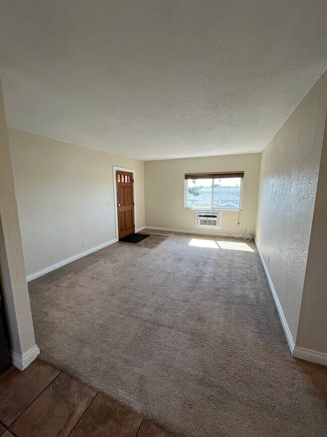 Entry and living room with AC unit and west facing window. - 5310 Rex Ave