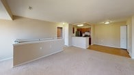 This upper-level unit features a thoughtfully arranged single-floor plan with three bedrooms and two full bathrooms. The open living area is finished with neutral-toned carpet and connects seamlessly to the kitchen via a peninsula-style breakfast bar. The galley kitchen is well-appointed with warm wood cabinetry, granite-look countertops, a stainless steel refrigerator, gas range, dishwasher, double sink, and light hardwood-style flooring, providing a functional workspace for cooking and meal preparation.

Each of the three bedrooms is carpeted and painted in soft, neutral tones, creating a calm and versatile environment. Several bedrooms feature windows that bring in natural light and offer exterior views, while closets provide practical storage solutions. The primary bedroom includes direct access to one of the two bathrooms, which features a vanity with dark wood cabinetry. Both bathrooms are equipped with tub-shower combinations lined with white tile surrounds and curved curtain rods. Throughout the unit, clean white trim, consistent neutral wall tones, and a straightforward layout contribute to an overall atmosphere that is functional, bright, and move-in ready.