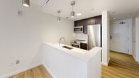 This 500 square foot apartment in Quincy, Massachusetts, offers a thoughtful blend of functionality and contemporary design. The one-bedroom, one-bathroom layout is efficiently arranged to maximize the available space. The kitchen is a standout feature, boasting modern stainless steel appliances, sleek dark cabinetry, and a white quartz countertop with an undermount sink. Pendant lighting adds a touch of sophistication to the space.

The living area is bright and airy, with light-colored walls and floors creating an open feel. Large windows in the bedroom allow natural light to flood the space, while providing views of the surrounding area. The bathroom is well-appointed with a modern vanity, large mirror, and spacious shower.

Throughout the apartment, the neutral color palette and clean lines contribute to a fresh, contemporary aesthetic. The use of materials such as wood-look flooring in the kitchen and plush carpeting in the bedroom adds warmth and comfort. Built-in closets and storage spaces help to keep the apartment organized and clutter-free.

Despite its compact size, this apartment offers all the essentials for comfortable urban living, making efficient use of every square foot. Its location at 1500 Hancock St places residents in the heart of Quincy, providing easy access to local amenities and transportation options.
