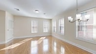 Located at 9-11 Vose Ave in South Orange, NJ, this well-appointed 2-bedroom, 2-bathroom residence offers a thoughtfully designed single-floor layout with generous living space. The open-concept living and dining area is a standout feature, showcasing gleaming hardwood floors and a bank of large windows that flood the room with natural light and offer views of the surrounding neighborhood. The kitchen is stylishly appointed with dark cabinetry, stainless steel appliances including a refrigerator, range, and microwave, complemented by a peninsula with pendant lighting that creates a natural divide between the kitchen and living areas. The spacious primary bedroom features plush carpeting and ample closet space, while the second bedroom also offers carpeted flooring and natural light through its windows. Both bathrooms are finished with white tile flooring, dark wood vanities, marble-look countertops, and illuminated mirrors. Additional highlights include two hallways, three closets for abundant storage, a dedicated utility room, and an in-unit laundry area housing a stacked washer/dryer and water heater. Neutral warm-toned walls throughout lend a clean, inviting ambiance to this move-in ready South Orange residence.