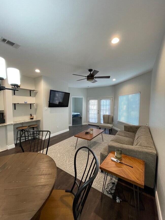 Sala de estar principal con vista a la puerta del dormitorio individual. - 5550 Spring Valley Rd