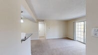 Located at 100 Lakeshore Dr NE in Atlanta, Georgia, this one-bedroom, one-bathroom residence offers a well-organized single-floor layout with a thoughtful mix of comfort and functionality. The open-concept living and dining area is carpeted throughout and bathed in natural light, with a sliding glass door leading to a private balcony that overlooks lush greenery. A textured ceiling and neutral warm-toned walls create a clean, inviting ambiance throughout the common areas. The kitchen features rich dark-stained cabinetry, granite countertops, a peninsula with a built-in sink and pendant lighting, hardwood-style flooring, and black appliances including a range and refrigerator — seamlessly connecting to the dining area. The bedroom is generously sized with plush carpet, a ceiling fan, a wide window that frames tree views, and access to a walk-in closet with built-in shelving. A second closet provides additional storage. The bathroom includes a granite-topped vanity, wood-style tile flooring, and a glass-enclosed shower. A dedicated laundry area and utility room add everyday convenience to this well-appointed Atlanta residence.