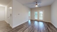 Located at 1220 Pennan Ln in Myrtle Beach, SC, this single-floor residence offers a well-designed layout with a cohesive blend of modern finishes and comfortable living spaces throughout. The open living area is highlighted by rich, dark hardwood-style flooring, neutral walls, a ceiling fan, and French doors that open to a private balcony, inviting an abundance of natural light and outdoor views. The kitchen is a standout feature, boasting rich espresso-toned cabinetry, granite countertops, a central island with a built-in sink, stainless steel appliances including a range, microwave, and refrigerator, and both pendant and track lighting for a polished, functional aesthetic. Light wood-style flooring completes the kitchen's contemporary look. The bedrooms are generously sized, each featuring plush carpeting, ceiling fans, and large windows dressed with blinds that frame views of the surrounding greenery and water. Closet space is ample, with dedicated storage accessible from the primary bedroom. The bathrooms are finished with granite-topped vanities, dark cabinetry, hardwood-style flooring, and tub-shower combinations, maintaining a consistent design language throughout the home.