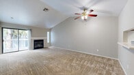 Located at 1100 E Leland Rd in Pittsburg, CA, this single-story residence offers three bedrooms and two bathrooms across a thoughtfully laid-out floor plan. The open-concept living and dining area serves as the heart of the home, highlighted by soaring vaulted ceilings, a ceiling fan with light fixture, and a classic fireplace framed by a clean white mantel. A sliding glass door opens to a private balcony, allowing natural light to fill the space and providing pleasant outdoor views. Neutral-toned carpet runs throughout the living areas and bedrooms, creating a warm and cohesive feel. The galley-style kitchen features warm wood cabinetry, white appliances including an electric range and refrigerator, a stainless steel sink with light countertops, and hardwood-style flooring that extends into the bathrooms. The primary bedroom offers a comfortable footprint with a natural window view. The two additional bedrooms are well-sized, each with windows providing natural light. Both bathrooms are finished with oak-toned vanities, white countertops, and hardwood-style flooring — one featuring a walk-in shower with sliding glass doors and the other a full tub/shower combo. A dedicated laundry area and utility room add everyday convenience to this well-appointed home.