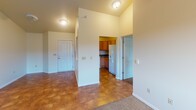 Located at 843 Oak Ave N in Onalaska, Wisconsin, this single-floor unit offers a thoughtfully laid-out living space with a clean, neutral aesthetic throughout. The entryway opens to a tiled foyer area with soaring vaulted ceilings, providing an immediate sense of openness as it connects to the kitchen and living areas. The kitchen is equipped with warm oak cabinetry, dark laminate countertops, an electric range, an over-the-range microwave, and a refrigerator, offering ample storage and prep space. The carpeted living and bedroom areas feature ceiling fans with integrated lighting and large windows fitted with blinds that allow generous natural light and outdoor views of the surrounding landscape. Baseboard heating is present throughout the carpeted rooms, ensuring consistent warmth. One of the bedrooms includes a built-in closet with bifold doors, adding practical storage. The bathrooms feature warm-toned tile flooring, a vanity with a white countertop and wood-grain cabinetry, and a bathtub-shower combination with a grab bar. The overall interior presents a neutral color palette of soft whites and beiges, creating a bright, versatile living environment suitable for a variety of occupants.