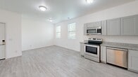 Located at 265 E Old Hickory Blvd in Madison, Tennessee, this 2-bedroom, 2-bathroom unit offers a clean, modern aesthetic across its single-level, efficiently arranged floor plan. Light-toned luxury vinyl plank flooring runs throughout the entire space, creating a cohesive and easy-to-maintain foundation in every room.

The kitchen is thoughtfully equipped with stainless steel appliances, including a range, over-the-range microwave, dishwasher, and refrigerator. Gray shaker-style cabinetry pairs with granite-look countertops to provide both storage and workspace, while an adjacent open area with dual windows allows natural light to fill the combined living and kitchen zone.

Both bedrooms feature white walls, natural light from windows, and bi-fold closet doors for organized storage. The primary bedroom offers a comfortable footprint with direct proximity to one of the two bathrooms. The second bedroom is similarly bright and well-proportioned.

The bathrooms maintain the unit's modern style, featuring light flooring, clean white finishes, and walk-in glass-enclosed tiled showers with grab bars for accessibility. The overall ambiance is bright, neutral, and move-in ready, suited for practical, comfortable everyday living.