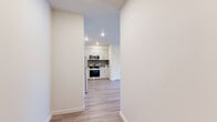 Located at 10807 E Empire Ave in Spokane Valley, WA, this thoughtfully designed one-bedroom, two-bathroom unit offers a clean, contemporary aesthetic throughout its single-floor layout. Light wood-style flooring flows seamlessly across all living areas, complementing the bright, neutral color palette that gives the space an open and airy feel.

The combined kitchen and living area serves as the heart of the unit. The kitchen is well-appointed with white shaker-style cabinetry, white countertops, a geometric tile backsplash, and a full suite of stainless steel appliances including a range, over-the-range microwave, refrigerator, and dishwasher. The adjoining living room is generously sized, featuring recessed lighting, a wall-mounted mini-split HVAC unit, and sliding glass doors that open to a private balcony with exterior views.

The bedroom offers a comfortable footprint with a large window that brings in natural light, recessed ceiling lighting, and a double louvered-door closet. Two bathrooms provide added convenience, one featuring a full soaking tub with shower combination and chrome fixtures. Additional storage is available through two closets found throughout the unit. Clean lines and modern finishes make this a polished, move-in ready space.