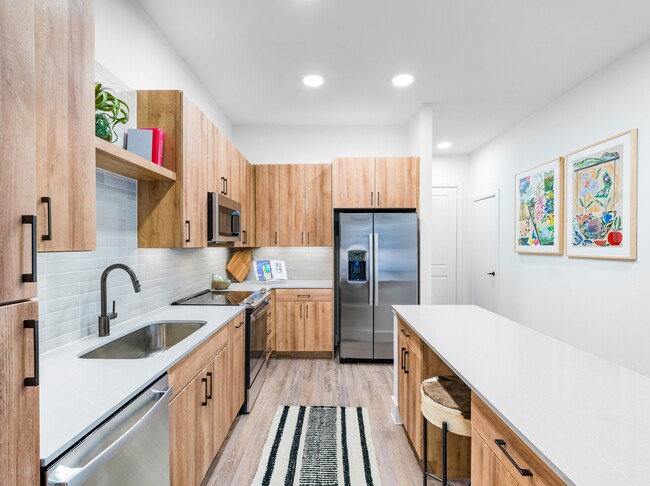 Experience culinary excellence in Modera Trinity's gourmet kitchens, adorned with sleek quartz countertops and stylish tile backsplashes. - Modera Trinity