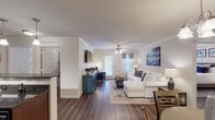 Located at 200 Carolina Point Pkwy in Greenville, South Carolina, this single-story residence offers a well-organized layout with a cohesive design throughout. Dark hardwood-style flooring runs consistently across all rooms, providing a warm and unified aesthetic complemented by neutral wall tones and white trim.

The living room is open and comfortably proportioned, featuring crown molding, a ceiling fan, and a glass-paneled door that brings in natural light. The adjacent dining area is defined by an elegant chandelier and crown molding, creating a welcoming setting for meals. The kitchen is equipped with dark espresso cabinetry, granite-style countertops, black appliances, a tiled backsplash, and a breakfast bar with pendant lighting overhead — offering both functionality and visual appeal.

The bedrooms each include ceiling fans and generous closet space; one bedroom notably features a walk-in closet. Both bathrooms are finished in neutral tones — one includes a soaking tub and extended vanity with ample counter space, while the second offers a tub-shower combination with a large mirror and single vanity. The overall ambiance throughout is clean, comfortable, and practical.