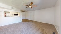 Located at 2300 W San Angelo St in Gilbert, AZ, this 2-bedroom, 1-bathroom residence offers a practical and well-organized single-floor layout. The open living room is finished with plush carpeting, a textured ceiling, and a ceiling fan with light fixture. Sliding glass doors lead to a private balcony, allowing natural light to fill the space and providing outdoor views. The kitchen flows directly off the living area and features light hardwood-style flooring, white cabinetry, a black refrigerator, and a black electric range, with a pass-through counter connecting to the living space. Both bedrooms are carpeted and include ceiling fans, textured ceilings, and windows that bring in natural light. The primary bedroom is generously sized with ample wall space for furnishings. The second bedroom also offers a comfortable footprint and good natural light. The full bathroom is clean and bright, featuring a tub-shower combination with a curved curtain rod, wood-style flooring, and a speckled countertop vanity. Throughout the residence, white walls and neutral tones create a bright, cohesive atmosphere that is easy to personalize.
