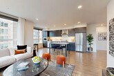 Located at 16505 Redmond Way in Redmond, WA, this well-appointed 2-bedroom, 2-bathroom residence offers a thoughtfully designed single-level layout with a clean, modern aesthetic. The open-concept living, dining, and kitchen area serves as the heart of the home, bathed in natural light from expansive floor-to-ceiling windows that frame views of the surrounding neighborhood. Light wood-tone flooring runs throughout, creating a warm and cohesive feel.

The contemporary kitchen is equipped with stainless steel appliances, including a refrigerator, dishwasher, and range, complemented by dark wood cabinetry, white quartz countertops, and a central island with bar seating. A dedicated dining area flows naturally from the kitchen into the spacious living room, which features a wall-mounted mini-split system for climate control.

The primary bedroom is generously sized, offering large windows with outdoor views and a sliding-door closet. The second bedroom provides a comfortable retreat with its own closet space. Both bathrooms are finished with white subway tile, quartz vanities, and dark wood cabinetry. A clean, minimalist entrance with a built-in mirror welcomes residents home. Four closets throughout the residence provide ample storage.