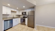 Located at 9700 Hamlin Blvd in Seminole, Florida, this single-floor, 2-bedroom, 2-bathroom residence offers a functional and well-appointed layout. The kitchen stands out with crisp white shaker cabinetry, granite-look countertops, recessed lighting, a textured ceiling, and a full suite of stainless steel appliances including a refrigerator, range, over-the-range microwave, and dishwasher. Light-toned ceramic tile flooring flows through the kitchen and living areas, contributing to a bright, clean aesthetic. The spacious living room features sliding glass doors with vertical blinds, providing access to an outdoor area and allowing natural light to fill the space. Both bedrooms are carpeted and feature neutral wall tones and windows with blinds. The primary bedroom is generously sized, offering dual closets with bifold doors for ample storage. The second bedroom also features a closet and a window with natural light. Each bathroom is finished with tile flooring, a white vanity, and a toilet. One bathroom includes a tub-shower combo, while the other features a standalone shower stall. A hallway connects the bedrooms and bathrooms, rounding out a practical and comfortable floor plan.