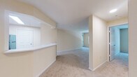 Located at 11402 Esplanade Dr in Reston, Virginia, this single-floor residence offers a thoughtfully arranged layout with a warm, neutral palette of soft cream tones throughout. The living area is generously proportioned, featuring plush wall-to-wall carpeting and a large window that frames lush, tree-lined views, filling the space with natural light. An open pass-through connects the living area to the kitchen, which is equipped with light maple cabinetry, white countertops, a stainless steel sink, and stainless steel appliances including a gas range and over-the-range microwave. Built-in shelving near the kitchen pass-through adds a functional decorative element to the common area.

The bedrooms are carpeted and well-sized, each benefiting from natural light. One bedroom features sliding glass door access to a private outdoor patio, while another has a large picture window overlooking greenery. Both bathrooms feature light wood vanity cabinetry, white countertops, large mirrors, and light hardwood-style flooring. One bathroom includes a tiled tub-shower combination, while the other offers a streamlined vanity layout. The overall ambiance is clean, bright, and move-in ready.