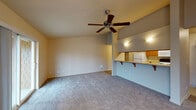 Located at 13250 SE 162nd Ave in Happy Valley, Oregon, this single-floor residence offers a well-designed layout with a comfortable, functional flow throughout. The open living area is a standout feature, boasting vaulted ceilings and a ceiling fan that enhance the sense of spaciousness. Plush wall-to-wall carpeting runs through the living and bedroom areas, adding warmth underfoot.

The kitchen is efficiently designed as a galley-style space with warm wood cabinetry, granite-look countertops, and white appliances including a refrigerator, electric range, dishwasher, and microwave. A pass-through counter with a breakfast bar connects the kitchen to the living area, making the layout ideal for everyday living. A dedicated laundry area with a full-size washer and dryer is conveniently accessible directly from the kitchen. Light vinyl flooring runs through the kitchen and utility spaces.

The bedrooms are generously sized with soft carpeting, large windows that invite natural light, and access to closet storage. The bathrooms are finished with warm wood vanities, light countertops, a large mirror, and a shower-tub combination. Overall, this residence presents a practical and comfortable living environment with thoughtful design details throughout.