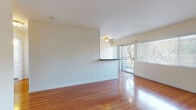Located at 2059 W Artesia Blvd in Torrance, California, this single-floor unit offers a well-organized layout with a variety of functional living spaces. The open living area is a standout feature, showcasing warm hardwood flooring that gleams with natural light streaming in through large windows and a sliding glass door that leads to a private balcony with outdoor views. A ceiling fan adds comfort to the space, while vertical wood panel accents on one wall lend a subtle design character. A half-wall divider with a bar-height ledge separates the living area, adding architectural interest without closing off the open feel.

The galley-style kitchen is efficiently laid out with white cabinetry, dark countertops, stainless steel appliances including a gas range and microwave, and a sink with ample workspace on both sides. Hardwood flooring continues throughout the kitchen, maintaining a cohesive aesthetic.

The bedroom offers plush carpeting and a wide window dressed with vertical blinds, allowing for adjustable natural light and privacy. The full bathroom is clean and bright, featuring a tiled tub-and-shower combination, a window for natural ventilation, a toilet, and a vanity with a light countertop. Hardwood-style flooring completes the bathroom's fresh, neutral look throughout this well-maintained Torrance residence.