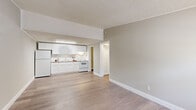 Located in Temple Terrace, FL, this well-designed one-bedroom, one-bathroom unit offers a thoughtfully arranged floor plan that maximizes every inch of its compact footprint. Light-toned luxury vinyl plank flooring flows consistently throughout the space, complemented by neutral warm-gray walls, crisp white trim, and textured ceilings that tie the interior together cohesively.

The open living and kitchen area forms the heart of the unit. The kitchen is outfitted with white shaker-style cabinetry extending to the ceiling, a subway tile backsplash, a full suite of white appliances including a refrigerator, electric range, and integrated overhead lighting, creating a clean and functional cooking space. The adjacent living area offers an open, airy feel with easy sightlines throughout.

The bedroom is a comfortable, well-proportioned retreat featuring a ceiling fan with light fixture, a window that invites natural light, and durable wood-tone flooring in a slightly deeper finish. Crown molding and clean white baseboards add a refined touch throughout.

The bathroom is efficiently designed with a single vanity featuring white cabinetry, a full-width mirror, and a combined tub and shower enclosure. A utility room and hallway complete the layout, adding practical storage and flow. This unit delivers a clean, move-in-ready living experience.