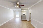 Located at 2501 Whitney Lawn Dr in Metairie, Louisiana, this two-story home offers a well-organized layout across two levels. The main floor features an open living room adorned with light hardwood-style flooring, crown molding, and a ceiling fan, creating a bright and comfortable atmosphere. Natural light filters in through a window at the far end of the room, enhancing the airy feel. Adjacent to the living area, a galley-style kitchen is efficiently designed with white cabinetry, ample counter space, a double stainless steel sink, and appliances including an electric range and refrigerator. A half bathroom on the main level provides added convenience for guests.

A wood-railed staircase leads to the upper level, where the generously sized primary bedroom awaits. Finished with plush carpet, crown molding, and a ceiling fan, this spacious retreat offers a comfortable and private sanctuary. A window provides natural light, while a dedicated en-suite bathroom features a tub/shower combination and hardwood-style flooring. The upper level also includes additional open space, ideal for a sitting area or home office. Throughout the home, a neutral color palette and consistent finishes contribute to a cohesive and inviting aesthetic.
