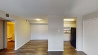 Located at 3825 William Dehaes Dr in Irving, TX, this single-story unit offers a straightforward, functional layout with consistent wood-style flooring running throughout. The open living area is generously sized, with neutral-toned walls, textured ceilings, and multiple windows that allow natural light to filter in. A front entry door opens directly into this expansive main living space, which flows seamlessly toward the kitchen area.

The kitchen is defined by a structural half-wall column that partially separates it from the living space while maintaining an open feel. It features white cabinetry on both upper and lower levels, a tile backsplash with a decorative mosaic accent band, light-toned countertops, a double stainless steel sink, and black appliances including a range and refrigerator.

The bedroom is a well-proportioned room with a window fitted with blinds that provides outdoor views and natural light, complemented by the same wood-style flooring found throughout the unit.

The bathroom includes a white tub-shower combination, a toilet, and a vanity with white cabinetry, a single-basin sink, granite-style countertops, and a large mirror above. The overall ambiance of the space is clean, neutral, and move-in ready.