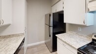 Located at 730 Via De Luna in Corona, California, this single-story unit offers a clean, modern aesthetic with a cohesive design throughout. Wood-look plank flooring flows continuously across the living areas, complemented by neutral gray walls and crisp white trim that create a bright, welcoming atmosphere. Textured ceilings add a classic touch throughout the space.

The open-concept living area is generously proportioned, featuring a large window with vertical blinds that draws in natural light and offers views of the surrounding exterior. A front entry door with an adjacent window further enhances the natural brightness of the main living space.

The kitchen is well-appointed with white cabinetry, granite-style countertops, a subway tile backsplash, and stainless steel appliances including a refrigerator and gas range. Ample upper cabinet storage makes the kitchen both functional and visually appealing.

The bedroom is a comfortable, well-lit room with a window overlooking the exterior, wood-look flooring, and a dedicated interior door providing privacy. The bathroom features a full tub-shower combination, a vanity with granite-style countertops, white cabinetry, and brushed nickel fixtures, all finished in a clean, neutral palette. This unit offers a practical and updated living environment in Corona, CA.
