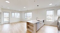 Located at 501 Orleans St in Richmond, VA, this thoughtfully designed one-bedroom residence offers a bright and modern living experience across a single floor. The open-concept kitchen and living area serves as the heart of the unit, featuring light hardwood flooring, crisp white walls, and abundant natural light from large windows overlooking the surrounding neighborhood. The kitchen is a standout, equipped with bold navy blue cabinetry, stainless steel appliances including a refrigerator and range, a white quartz peninsula with built-in shelving, a stainless sink, and a sleek linear pendant light above — combining style with everyday functionality. The living area flows seamlessly from the kitchen, with access to a private balcony offering open views of Orleans Street and the surrounding Richmond neighborhood. The bedroom is carpeted for comfort and features two large corner windows that flood the space with natural light, along with built-in wood-toned wardrobe cabinetry and a window seat with storage beneath — a practical and charming detail. Two closets provide ample storage throughout the unit. Additional conveniences include a dedicated laundry area and two full closets. The overall design aesthetic is clean, contemporary, and move-in ready.