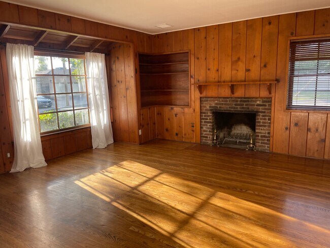 Living room with knotty pine walls and fireplace - 900 S Kenneth Rd