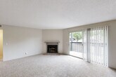 Located at 1269 Mangrove Ln in Saint Louis, MO, this well-appointed one-bedroom, two-bathroom home offers a comfortable and functional single-floor layout. The open living room is a standout space, featuring plush carpeting, a textured ceiling, and a classic wood-burning brick fireplace with a clean mantel. A sliding glass door floods the room with natural light and provides direct access to a private outdoor balcony with a wooden railing, offering pleasant views of surrounding greenery. The living area connects seamlessly to the kitchen and dining space, where wood-look flooring, a ceiling fan with light fixture, and a pass-through counter create an airy, practical atmosphere. The galley-style kitchen is well-equipped with white upper cabinetry, gray lower cabinets, light stone countertops, a stainless steel sink, black appliances including a refrigerator and dishwasher, and a dedicated pantry closet. The spacious bedroom features soft carpeting, a natural light window, and direct access to a dedicated closet. Both bathrooms are finished with wood-look flooring, neutral tones, and clean vanities with ample mirror and storage space. The overall ambiance is bright, neutral, and move-in ready.