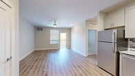 Located at 2300 Swift St in North Kansas City, MO, this well-appointed one-bedroom, one-bathroom unit offers a thoughtfully designed layout across a single floor. The open living area features warm luxury vinyl plank flooring, neutral-toned walls, a ceiling fan, and a sliding glass door leading to a private balcony with outdoor views, allowing natural light to fill the space.

The kitchen is a standout feature, showcasing white shaker-style cabinetry, granite-look countertops, a mosaic tile backsplash in shades of gray and white, and a full suite of stainless steel appliances including a refrigerator, range, microwave, and dishwasher. LVP flooring continues seamlessly throughout the kitchen and living areas.

The bedroom is a comfortable size, finished with plush carpet, a ceiling fan, and a window with blinds providing natural light. It includes access to a walk-in closet equipped with multi-tiered wire shelving for ample storage. The bathroom features a full soaking tub and shower combination with built-in shelving, set in a clean, all-white finish with LVP flooring. The overall aesthetic is modern and move-in ready, with a clean, cohesive design throughout.