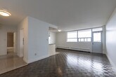 Located at 1080 Kingston Rd in Toronto's Upper Beaches neighbourhood, this one-bedroom, one-bathroom unit offers a well-organized layout across a single floor. The open-concept living, dining, and kitchen area forms the heart of the unit, bathed in natural light from large floor-to-ceiling windows that frame sweeping city views and provide access to an outdoor balcony. The living and dining space features classic parquet wood flooring throughout, lending warmth and character to the bright, white-walled interior. The kitchen is efficiently designed in a galley style, showcasing white shaker cabinetry with brushed nickel hardware, granite countertops, a subway tile backsplash, and a full suite of stainless steel appliances including a refrigerator, stove, and dishwasher. A peninsula counter separates the kitchen from the main living area, offering additional prep space. The bedroom is a comfortable, quiet retreat with parquet flooring, crisp white walls, and a window overlooking the neighbourhood. The bathroom is finished with large-format grey wall tiles, a soaker tub with overhead shower, a dark wood vanity with white basin, and tile flooring. The unit presents a clean, functional, and well-maintained living environment.