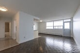 Located at 1080 Kingston Rd in Toronto's Upper Beaches neighbourhood, this one-bedroom, one-bathroom unit offers a well-organized layout across a single floor. The open-concept living, dining, and kitchen area forms the heart of the unit, bathed in natural light from large floor-to-ceiling windows that frame sweeping city views and provide access to an outdoor balcony. The living and dining space features classic parquet wood flooring throughout, lending warmth and character to the bright, white-walled interior. The kitchen is efficiently designed in a galley style, showcasing white shaker cabinetry with brushed nickel hardware, granite countertops, a subway tile backsplash, and a full suite of stainless steel appliances including a refrigerator, stove, and dishwasher. A peninsula counter separates the kitchen from the main living area, offering additional prep space. The bedroom is a comfortable, quiet retreat with parquet flooring, crisp white walls, and a window overlooking the neighbourhood. The bathroom is finished with large-format grey wall tiles, a soaker tub with overhead shower, a dark wood vanity with white basin, and tile flooring. The unit presents a clean, functional, and well-maintained living environment.