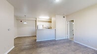 Located at 3775 W 25th St in Greeley, Colorado, this single-floor residence offers a practical and well-organized layout designed for comfortable everyday living. The open-concept main living area is anchored by durable wood-style flooring that runs throughout the entry, living, and kitchen spaces, creating a cohesive and easy-to-maintain environment. A peninsula-style kitchen features white cabinetry, a full suite of white appliances including a refrigerator, electric range, and microwave, along with a light-toned countertop that extends to a breakfast bar. A pendant light fixture adds a focal point above the dining area, which flows seamlessly into the living space. Natural light enters through sliding windows, enhancing the bright, neutral color palette of warm beige walls and white trim found throughout. The bedrooms are carpeted for added comfort, each offering closet storage and overhead ventilation. One bedroom benefits from a window with exterior views of the surrounding brick building. The bathroom is finished with a full tub and shower combination, a single-sink vanity with a speckled countertop, white cabinetry, and wood-style flooring. The entry door opens to a tiled foyer, providing a clean transition into the main living space.