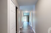 Located at 500 Piccadilly Row in Antioch, TN, this single-story apartment offers 1,310 square feet of well-designed living space across three bedrooms, two bathrooms, and four closets. The kitchen features white cabinetry, light countertops, wood-look plank flooring, and black appliances including a range and refrigerator. A window above the counter brings in natural light, and a dedicated in-unit laundry area with a full-size washer and dryer is conveniently accessible from the kitchen corridor. The living room is finished with the same durable wood-look flooring and includes a sliding glass door that opens to an outdoor view, allowing abundant natural light. The spacious primary bedroom measures 220 square feet, features plush carpeting, a ceiling fan, and multiple windows. It is complemented by a private bathroom with a granite-topped white vanity and an adjacent walk-in closet with wire shelving. The two additional bedrooms also feature carpet flooring, neutral walls, and natural light from windows. The second bathroom offers a full tub-shower combination, a granite-topped vanity, and wood-look flooring. Neutral taupe tones throughout the unit create a cohesive and inviting atmosphere.