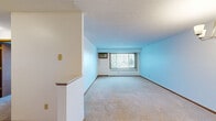 Located at 3415 Federal Dr in Eagan, MN, this two-bedroom, one-bathroom unit offers a practical and well-organized single-floor layout. The combined living and dining area provides an open, comfortable space with light-toned carpet, a textured ceiling, and a large window fitted with vertical blinds that allows natural light to flow in while offering views of the surrounding greenery. A wall-mounted air conditioning unit and baseboard heating ensure year-round comfort.

The kitchen features warm oak cabinetry with ample upper and lower storage, white appliances including a range, refrigerator, and dishwasher, light countertops, and tile flooring. It connects conveniently to the main living areas.

The primary bedroom is a well-proportioned space with carpeted flooring, a large window with outdoor views, and its own wall-mounted air conditioning unit. The second bedroom also offers carpet, a bright window, and a sliding oak closet door. Both rooms provide easy access to the shared full bathroom, which includes a tub/shower combination, tile flooring, and a vanity with storage.

Notably, the unit includes four closets throughout, offering generous storage. Textured ceilings and warm wood-toned trim and doors are consistent design elements across the space.