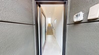 Located at 5159 W Mid City Ct in Los Angeles, this contemporary three-story residence showcases modern design principles with clean lines, bright white interiors, and high-quality finishes throughout. Entry is made through a sleek glass-and-steel door that opens into a crisp corridor with polished concrete-style flooring and a staircase with a refined metal handrail connecting all three levels.

The kitchen is well-appointed with floor-to-ceiling white shaker cabinetry, quartz countertops, a bold teal island, stainless steel appliances, and a decorative hexagonal tile backsplash, all set atop warm light hardwood floors. The living area is bright and airy, featuring recessed lighting and large glass sliding doors that open to an outdoor balcony, flooding the space with natural light and providing views of the surrounding neighborhood.

Bedrooms are serene and minimal, with large picture windows framing outdoor views, light hardwood flooring, and generous built-in wood-toned wardrobes for ample storage. The primary bathroom is spa-like, offering dual LED-backlit vanity mirrors, a double sink with quartz counters, grey cabinetry, and a glass-enclosed shower with patterned tile flooring. A secondary bathroom features a frameless glass shower enclosure, a floating toilet, and a clean, minimalist aesthetic. The property also includes an attached garage with direct access.