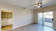 Located at 9620 W Russell Rd in Las Vegas, NV, this one-bedroom, one-bathroom unit offers a thoughtfully designed single-floor layout that maximizes every square foot of its cozy footprint. Light wood-style flooring flows consistently throughout the space, complementing the neutral warm-gray wall tones that lend a clean, modern aesthetic.

The combined kitchen and living area forms the heart of the unit. The kitchen is well-appointed with white shaker-style cabinetry, white quartz countertops, a stainless steel sink, dishwasher, refrigerator, and range with microwave—providing ample functionality. A breakfast bar-style counter separates the kitchen from the living area, which is enhanced by a ceiling fan with light fixture and a sliding glass door that opens to a private patio, inviting natural light and outdoor access.

The bedroom is a comfortable, well-proportioned retreat featuring its own ceiling fan, a window with blinds for natural light, and direct access to a closet and the hallway. The bathroom is clean and bright, featuring a wide vanity with white cabinetry, a vessel-style sink, a large wall mirror, and a shower-tub combination. A hallway connects all rooms efficiently, completing the practical and well-organized floor plan.