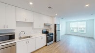 Located at 1001 Birdie Dr in Coraopolis, PA, this thoughtfully designed two-bedroom, two-bathroom residence offers a clean, modern aesthetic throughout its efficiently arranged single-floor layout. Warm wood-look flooring flows seamlessly through every room, complementing the bright white walls and recessed lighting that give the entire space a fresh, airy feel.

The kitchen is a standout feature, boasting an abundance of white shaker cabinetry extending to the ceiling for generous storage, paired with sleek light countertops and stainless steel appliances including a gas range and full-size refrigerator. The open sightline from the kitchen toward the living area enhances the sense of space and connectivity.

Both bedrooms are well-proportioned and filled with natural light. The primary bedroom offers a comfortable footprint, while a second bedroom benefits from a large window overlooking greenery. A spacious walk-in closet with full wire shelving systems provides excellent organization and storage capacity.

Each of the two full bathrooms features a tiled tub-shower combination with a curved curtain rod, white vanity cabinetry, and wood-look flooring, maintaining the home's consistent modern style. A dedicated in-unit laundry room houses a full-size front-loading washer and dryer, adding everyday convenience. Overall, the space presents a clean, move-in-ready environment with practical, well-appointed finishes throughout.