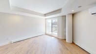 Located at 8 Walker Ave in Halifax, NS, this well-appointed one-bedroom, one-bathroom unit offers a thoughtfully designed open-concept layout finished with warm light wood flooring throughout. The combined kitchen and living area forms the heart of the unit, anchored by a sleek kitchen island with a white quartz countertop, double undermount sink, and a dishwasher. The kitchen features two-tone cabinetry in dark navy and natural wood tones, complemented by stainless steel appliances including a refrigerator. Recessed lighting and a tray ceiling detail add architectural interest to the living space, which is also equipped with a ductless wall-mounted air conditioning unit and baseboard heating. A distinctive cylindrical column adds a modern structural accent to the open living area. The living room benefits from a large sliding door and windows that invite natural light and provide views of the surrounding neighbourhood. The bedroom is a well-sized, quiet retreat featuring a built-in closet with clean white panel doors and matte black hardware. The bathroom is finished with large-format tile in a walk-in shower, a modern vanity with a white countertop, and recessed lighting. An in-unit laundry area completes this efficiently laid-out home.