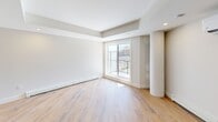 Located at 8 Walker Ave in Halifax, NS, this well-appointed one-bedroom, one-bathroom unit offers a thoughtfully designed open-concept layout finished with warm light wood flooring throughout. The combined kitchen and living area forms the heart of the unit, anchored by a sleek kitchen island with a white quartz countertop, double undermount sink, and a dishwasher. The kitchen features two-tone cabinetry in dark navy and natural wood tones, complemented by stainless steel appliances including a refrigerator. Recessed lighting and a tray ceiling detail add architectural interest to the living space, which is also equipped with a ductless wall-mounted air conditioning unit and baseboard heating. A distinctive cylindrical column adds a modern structural accent to the open living area. The living room benefits from a large sliding door and windows that invite natural light and provide views of the surrounding neighbourhood. The bedroom is a well-sized, quiet retreat featuring a built-in closet with clean white panel doors and matte black hardware. The bathroom is finished with large-format tile in a walk-in shower, a modern vanity with a white countertop, and recessed lighting. An in-unit laundry area completes this efficiently laid-out home.