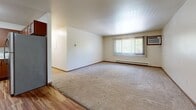 Located at 120 Cambridge Ave in Waukesha, Wisconsin, this well-appointed two-bedroom, two-bathroom residence offers a practical and comfortable single-floor layout. The kitchen is a functional highlight, featuring rich warm-toned cabinetry, light marble-style countertops, stainless steel appliances including a refrigerator, range, and dishwasher, and wood-style plank flooring that extends into the entryway and wet areas. The open transition between the kitchen and living area creates a natural flow, with the living room offering plush carpeting, a large window with vertical blinds that brings in natural light, and a baseboard heating system. The generously sized primary bedroom features carpeted flooring, a window overlooking the outdoors, and access to a dedicated walk-in closet outfitted with wire shelving on multiple walls for ample storage. The second bedroom is equally comfortable with carpeting and a classic wood-panel door. Both bathrooms are finished with wood-style flooring, dark vanity cabinetry, white countertops, and full tub-shower combinations. A ceiling fan is present in one area, adding to the overall comfort of the home. The neutral color palette throughout provides a clean, move-in ready canvas.