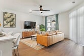 This thoughtfully designed 1-bedroom, 1-bathroom residence in Opelika, Alabama offers a functional and stylish single-floor layout. The open-concept living and kitchen area serves as the heart of the home, where warm wood-look flooring flows seamlessly underfoot. The modern kitchen stands out with two-tone cabinetry — white upper cabinets paired with natural wood-finish lowers — complemented by a white quartz countertop, a hexagonal tile backsplash, stainless steel appliances, and a center island with pendant lighting overhead. The living area offers generous space, ceiling fan, and large windows that invite natural light. The bedroom features plush carpet, a ceiling fan, large windows with drape treatments, and access to multiple closets with wire shelving systems for ample storage. The bathroom is appointed with wood-tone floating vanity, white quartz countertop, an illuminated mirror, and a subway tile tub-surround with matte black fixtures. An in-unit laundry area houses a full-size washer and dryer with overhead shelving. Three closets throughout the unit provide exceptional storage. Clean white walls and dark-accented doors lend a contemporary, cohesive aesthetic throughout this well-designed home.