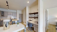 This thoughtfully designed single-floor residence in New Bern, NC offers a cohesive blend of modern finishes and functional living spaces. The kitchen is a standout feature, showcasing gray shaker-style cabinetry, granite countertops, stainless steel appliances including a range, microwave, refrigerator, and dishwasher, complemented by a classic white subway tile backsplash. Track lighting illuminates the space, and a freestanding butcher block island provides additional prep and storage space. A built-in desk nook with granite countertop and walnut floating shelves offers a convenient workspace just off the main living area. The bedrooms are bright and inviting, with large windows that welcome natural light and offer outdoor views. Ceiling fans add comfort, and the warm-toned flooring runs consistently throughout the home. The bathroom features gray cabinetry, granite countertops, brushed nickel fixtures, and a large mirror, creating a clean and polished aesthetic. A dedicated in-unit laundry area with a full-size washer and dryer and overhead shelving adds everyday convenience. The overall ambiance is modern, light, and functional, making this residence a comfortable and practical home.