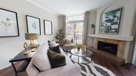 This thoughtfully designed single-floor residence combines modern comfort with classic architectural details. The living room serves as the heart of the home, anchored by a marble-surround fireplace set within a distinctive arched niche. Rich hardwood flooring flows throughout, complemented by crown molding and neutral tones that lend a warm, sophisticated ambiance. Large windows and floor-to-ceiling sliding glass doors flood the space with natural light while offering direct access to a private balcony overlooking mature trees — a serene outdoor retreat ideal for relaxing or dining al fresco.

The kitchen is well-equipped with white cabinetry, granite countertops, stainless steel appliances, and a double-basin sink, offering both functionality and style. Track lighting above provides clear, even illumination throughout the workspace.

The primary bedroom is a peaceful haven, featuring plush carpet, multiple windows with outdoor views, and sliding glass doors that open directly to the balcony. The en-suite bathroom is generously sized, with dual vanities, white cabinetry, hardwood flooring, a glass-enclosed shower, and a bay window seating area that brings in soft, diffused natural light — adding an airy, spa-like quality to the space.