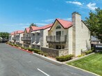 Located at 43100 30th St W in Lancaster, CA, Unit #113 is a thoughtfully designed single-floor residence that balances comfort and modern style. The entry hallway, finished with light wood-look flooring, leads seamlessly into the main living areas. The living room is bright and welcoming, featuring large sliding glass doors that open to a private patio with green outdoor views, allowing natural light to fill the space. A ceiling fan overhead and neutral wall tones contribute to the room's airy atmosphere. The kitchen is well-equipped with white shaker cabinetry, granite countertops, stainless steel appliances including a gas range, microwave, and refrigerator, and a window that brings in additional natural light. Adjacent to the kitchen, a dedicated dining area with a ceiling fan offers space for a dining table and counter seating at a granite-topped breakfast bar. The primary bedroom features plush carpet, a sliding glass window with outdoor views, and ample closet storage. A second bedroom, also carpeted, includes a built-in closet and a window overlooking the exterior. The bathroom is finished with dual sinks, granite countertops, and white cabinetry, providing generous storage. Textured ceilings are consistent throughout the unit.