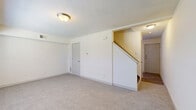 This two-story home in Columbus, Ohio offers a practical and well-organized layout across two floors. The main level features a carpeted living room with a textured ceiling, flush-mount lighting, and a staircase leading to the upper floor. The kitchen is equipped with dark cabinetry, a white refrigerator, a gas range, and a double sink, complemented by light wood-look flooring. Notably, the kitchen also accommodates an in-unit washer and dryer, adding significant everyday convenience. A patio and utility room round out the lower level.

Upstairs, three carpeted bedrooms each offer natural light through blinded windows. The bedrooms feature neutral tones and closets with built-in shelving for storage. One room on this level has wood-look flooring and a window overlooking the exterior. The shared full bathroom includes a tub-shower combination, toilet, vanity with dark cabinetry, wood-look flooring, and a small window for ventilation. Throughout the home, a consistent palette of white and warm neutral walls creates a clean, bright atmosphere. With five closets distributed across the home, storage is well addressed throughout this efficiently designed two-story residence.